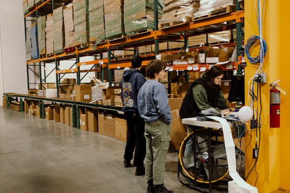 workers standing behind packages in a warehouse